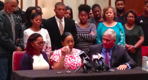 Kyrie Rose (left), and attorney Robert Mongeluzzi (right) comfort Lisa Berry (center) during a press conference in Indianapolis on Tuesday, July 31.
